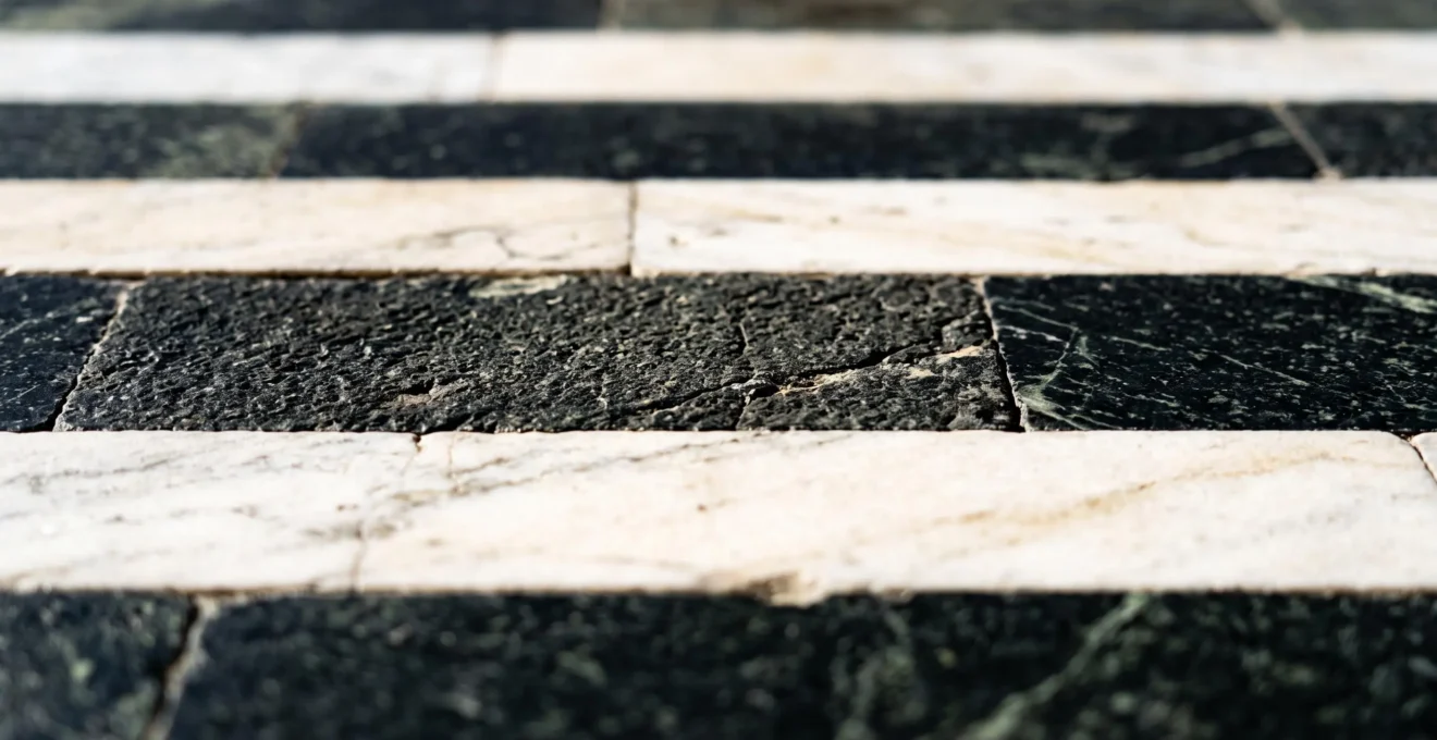 Extreme close-up of Siena cathedral's distinctive black and white striped marble facade showing intricate Gothic architectural detail and stone texture